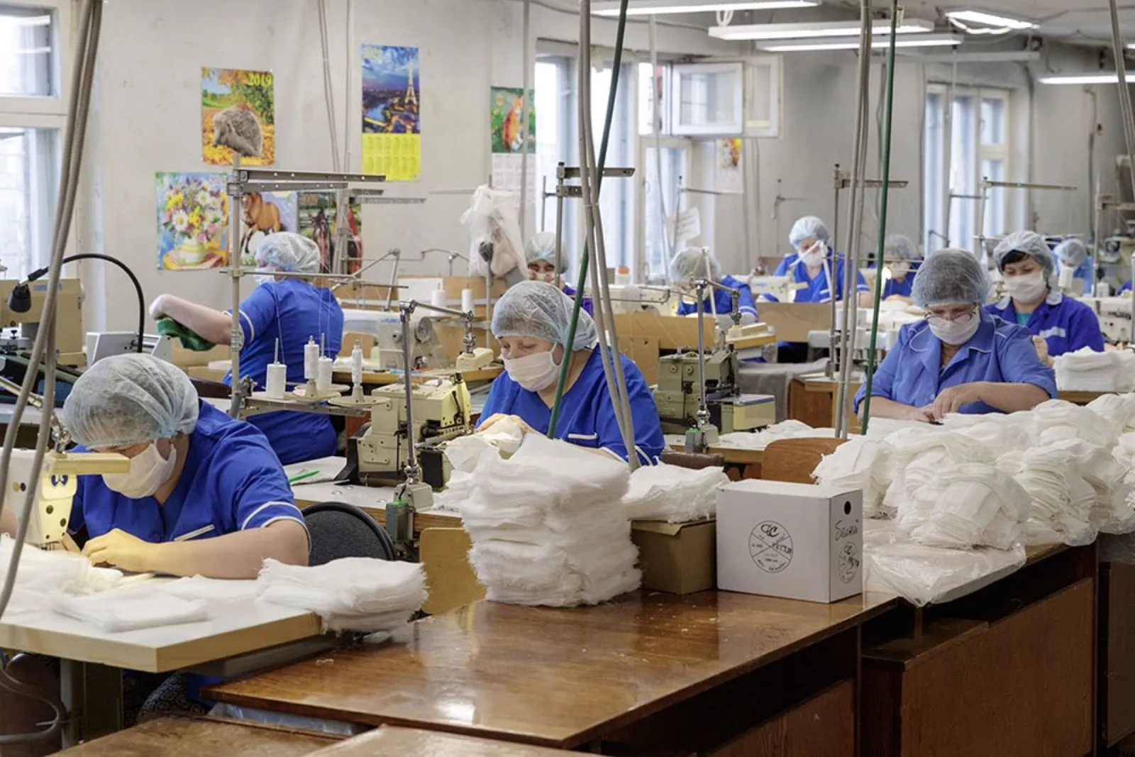 Costureiras trabalhando numa oficina de malhas clara